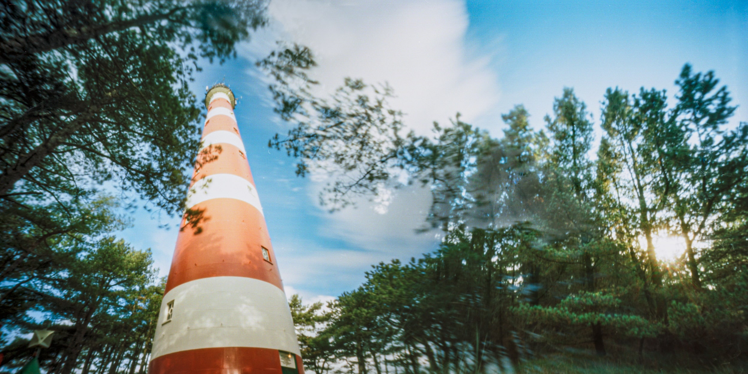 Pinhole photograph: a traffic cone against sky and trees